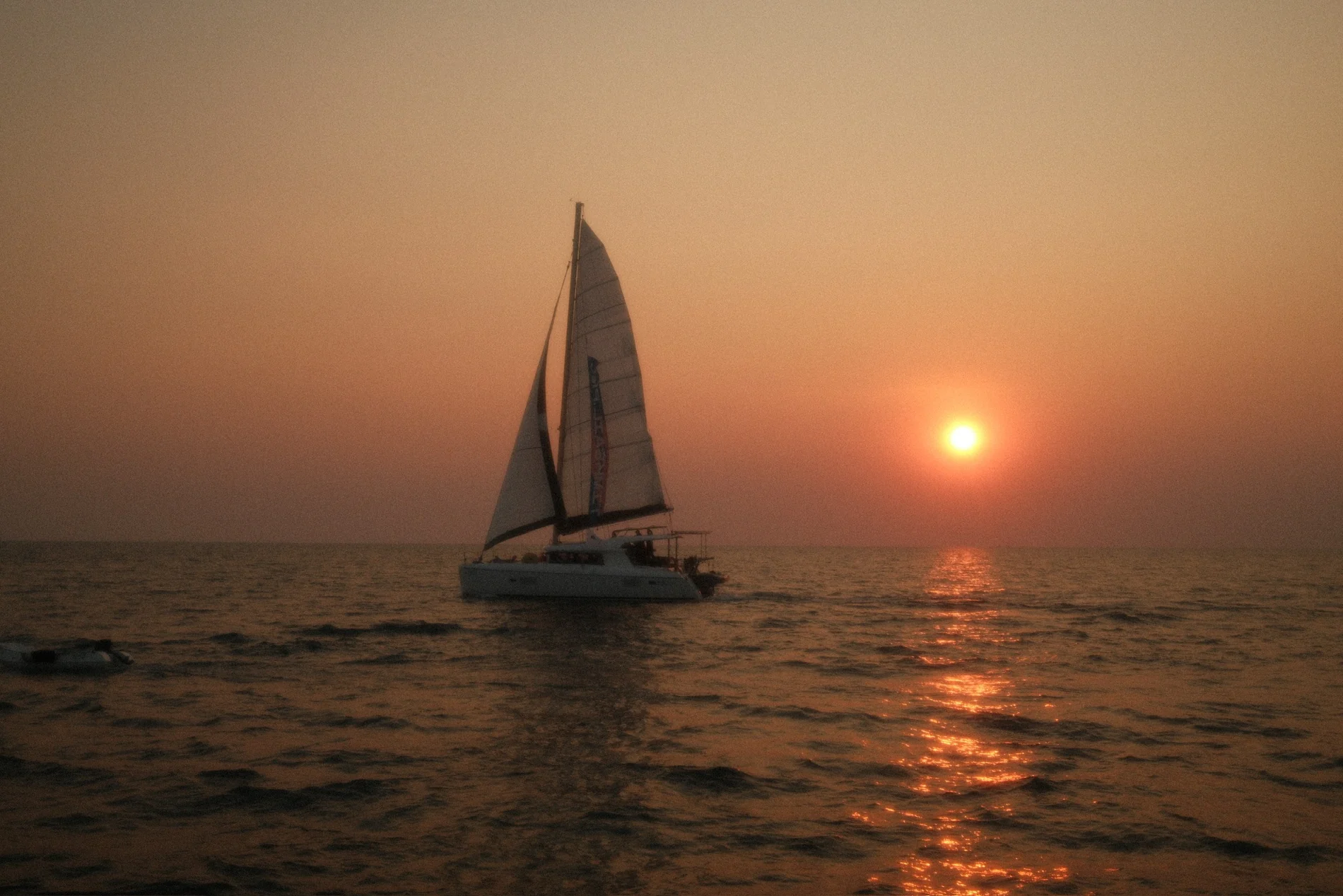 Яхта Sailing Man идёт в море на закате